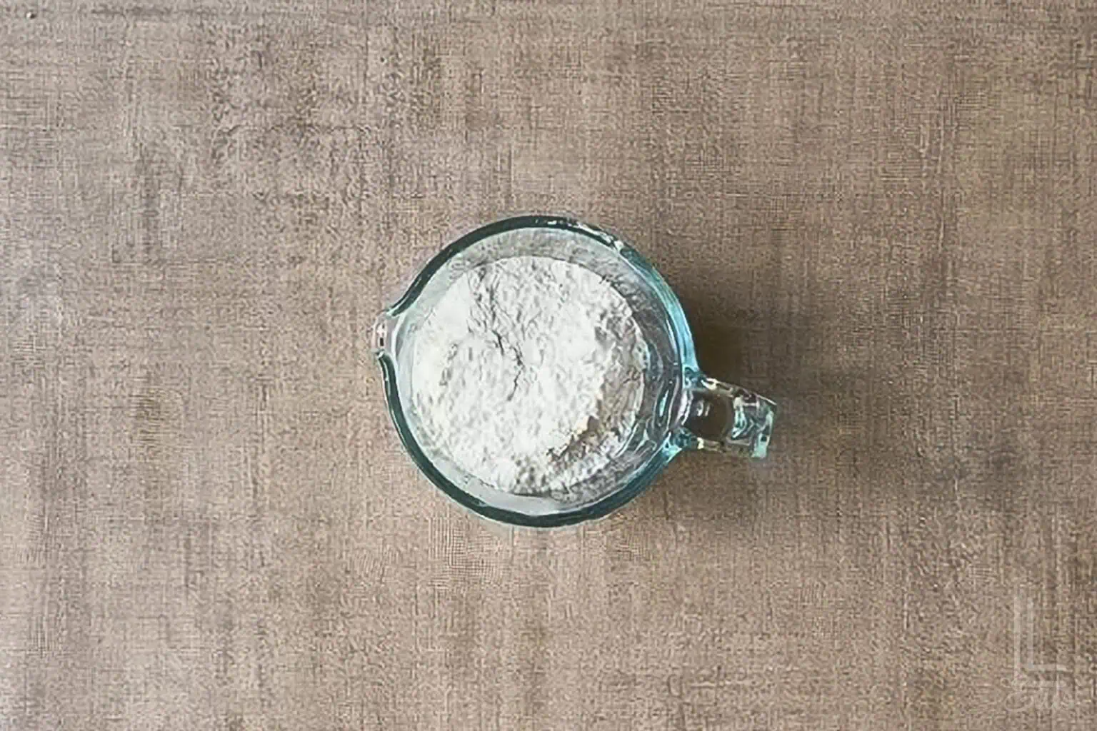 Measuring cup of dry ingredients (including flour).