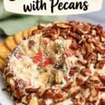 Pineapple cheese ball with bacon, nuts, and colorful ingredients on a plate.