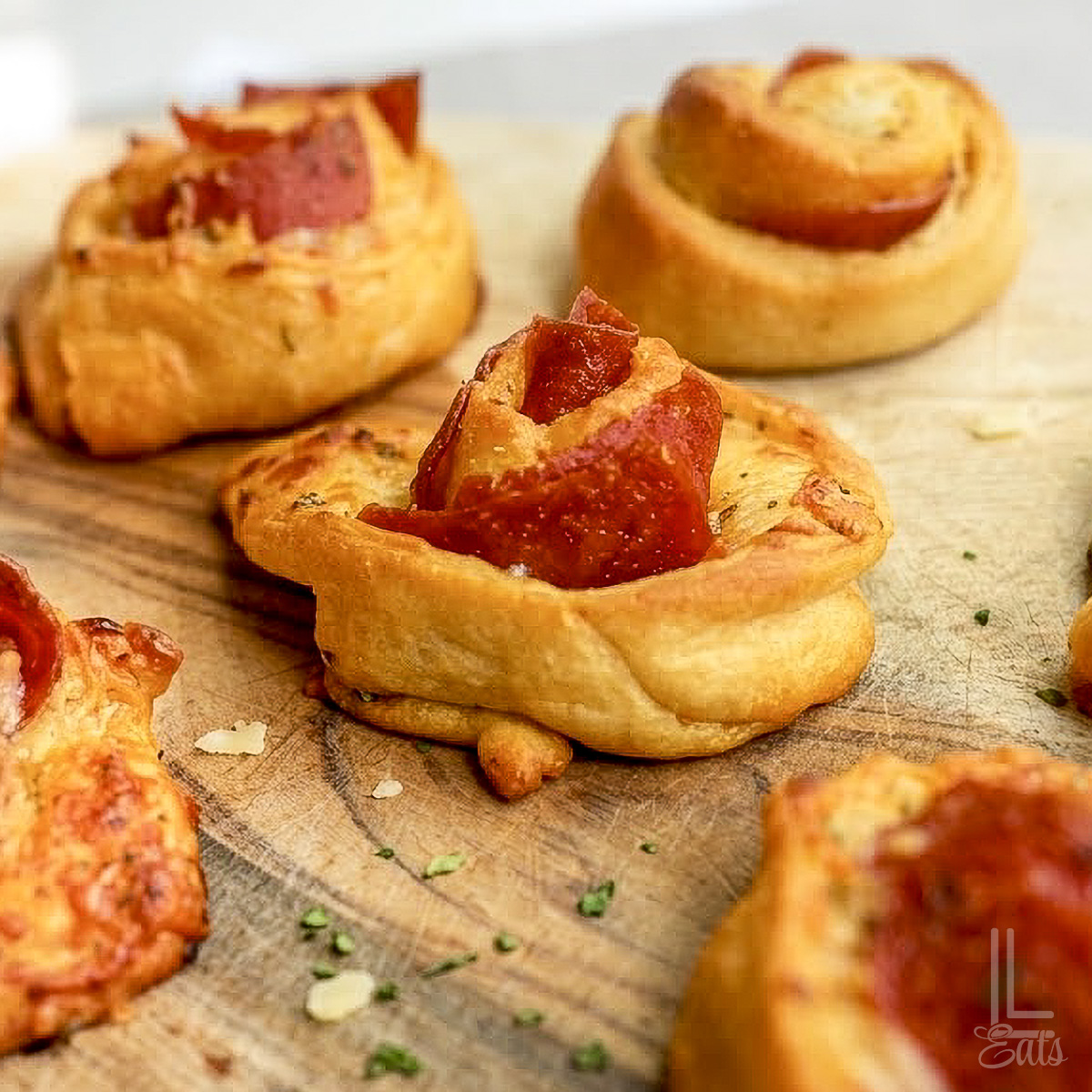 Pizza roll ups with pepperoni on a cutting board.