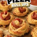 Crescent roll pepperoni pizza roll ups on a wooden surface with marinara sauce.